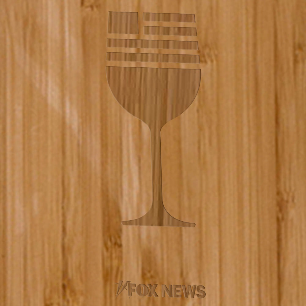 The *FOX News* Wine Bottle Cutting Board displayed on a clean wooden countertop next to kitchen accessories in a suburban home setting.