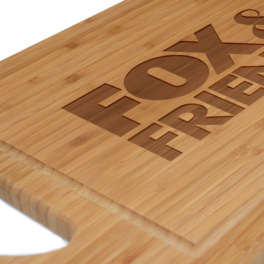 The *FOX & Friends* laser engraved board standing upright on a wooden shelf next to a window in a bright kitchen.