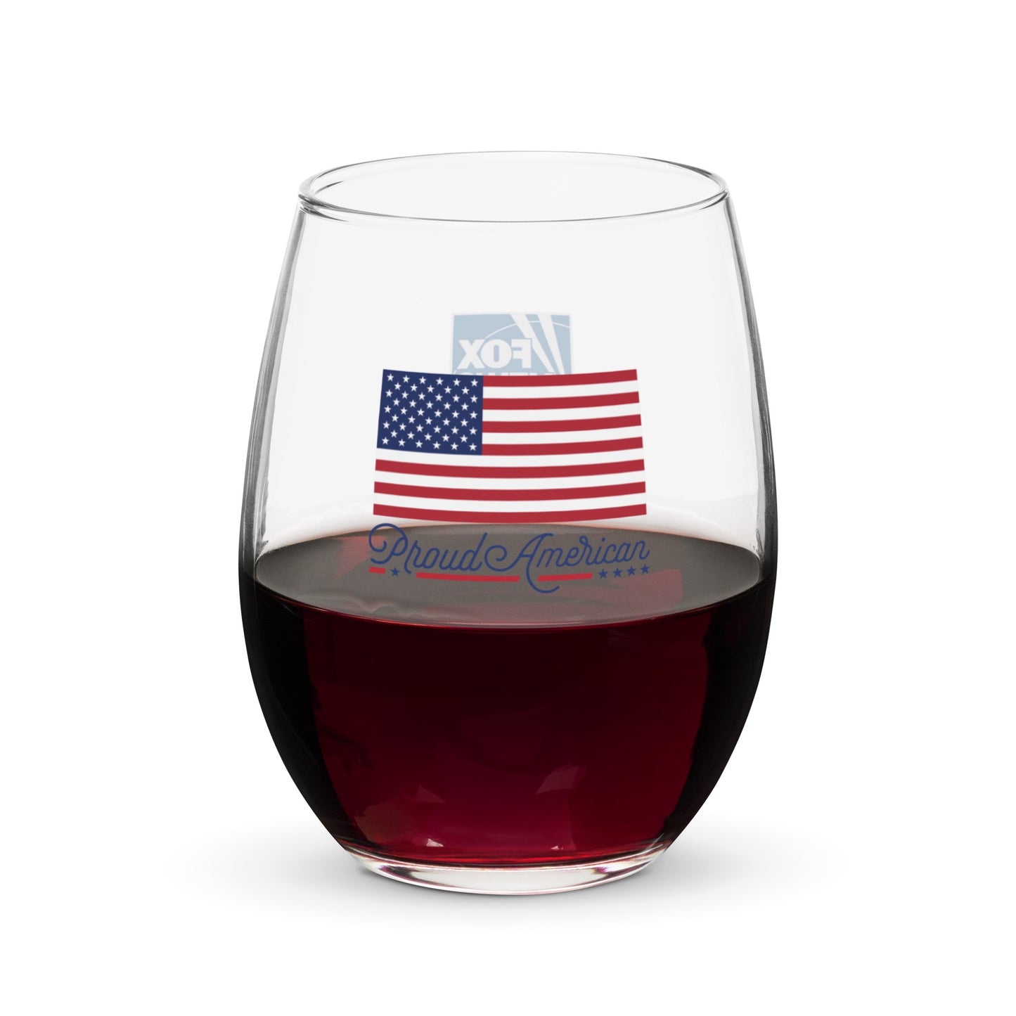 A clear FOX News Proud American stemless wine glass featuring a crisp logo, sitting on a wooden table in a sunlit American kitchen.