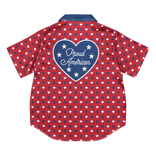 A woman relaxing in a clean, modern American living room wearing the FOX News Proud American Hearts And Stars women's short sleeve pajama top, smiling comfortably.