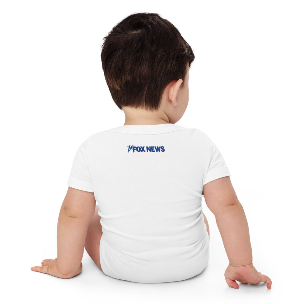 A lifestyle shot of the FOX News Proud Little American baby bodysuit in a comfortable family living room setting.
