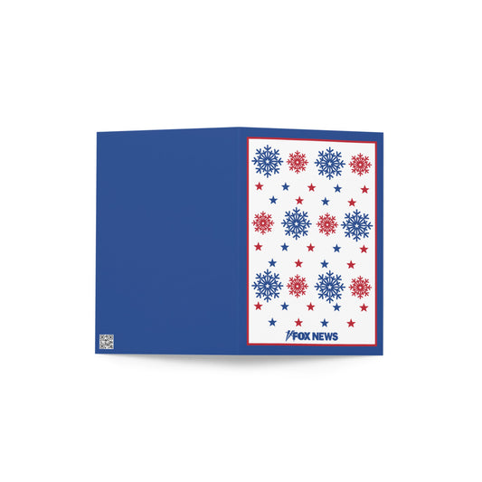 A FOX News Holiday Snowflakes Greeting Card resting on a clean wooden table in a sunlit American home.