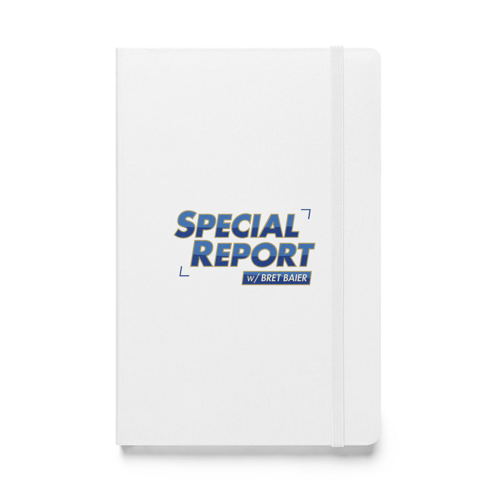 A white Special Report with Bret Baier journal resting next to a cup of coffee in a bright, professional suburban living room environment.