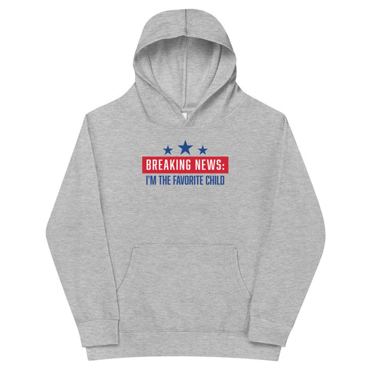 A child wearing the FOX News Breaking News Kids Hoodie in Athletic Heather, featuring the bold Breaking News logo, in a bright suburban home setting.