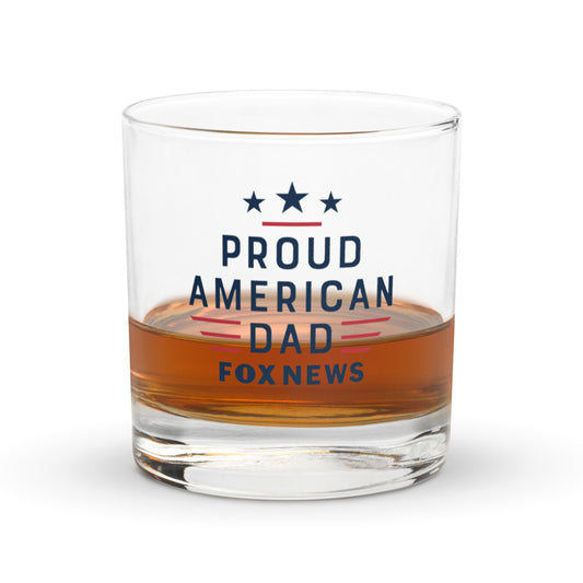 Official FOX News Proud American Dad rocks glass with a crisp logo and patriotic graphic on a dark wooden table.
