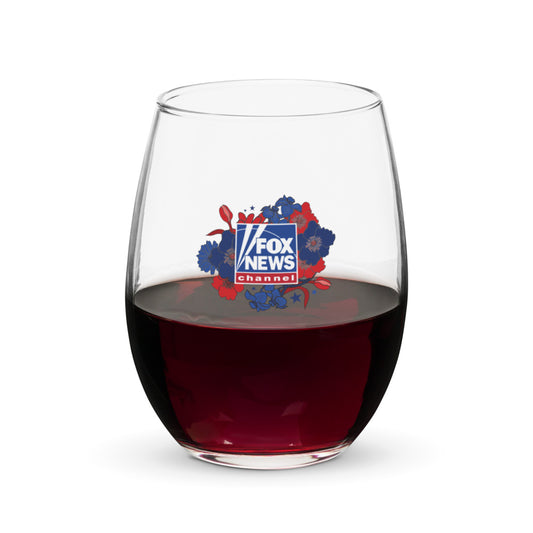 A clear 15-ounce stemless wine glass featuring the Proud American Mom design with crisp FOX News branding, set against a modern American living room background.