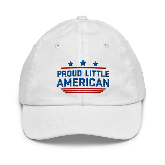 A young child wearing a white FOX News Proud Little American kids hat in a sunny American backyard setting.