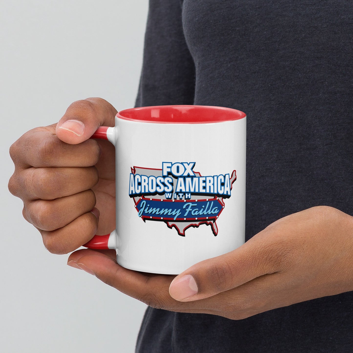 The red and white *FOX Across America* mug positioned next to a laptop in a modern, professional home office.
