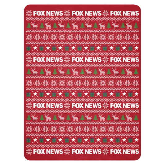 A cozy FOX News Holiday Sherpa Blanket spread out in a modern American living room setting.