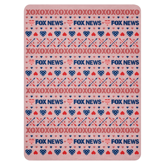 A cozy American living room setting featuring the FOX News Heart Sherpa Blanket draped neatly over a comfortable sofa.