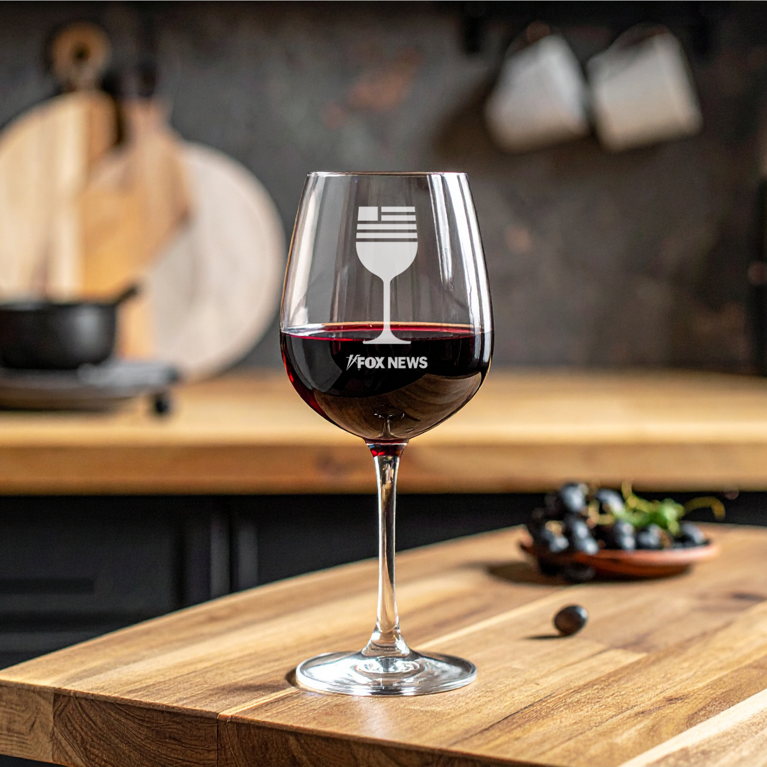 A crisp FOX News logo laser-engraved on a high-quality 17 oz stemmed wine glass, set in a clean and comfortable American home setting.