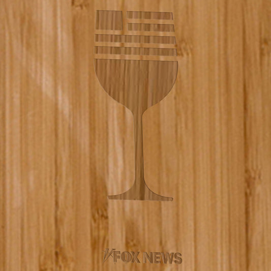 The *FOX News* Wine Bottle Cutting Board displayed on a clean wooden countertop next to kitchen accessories in a suburban home setting.