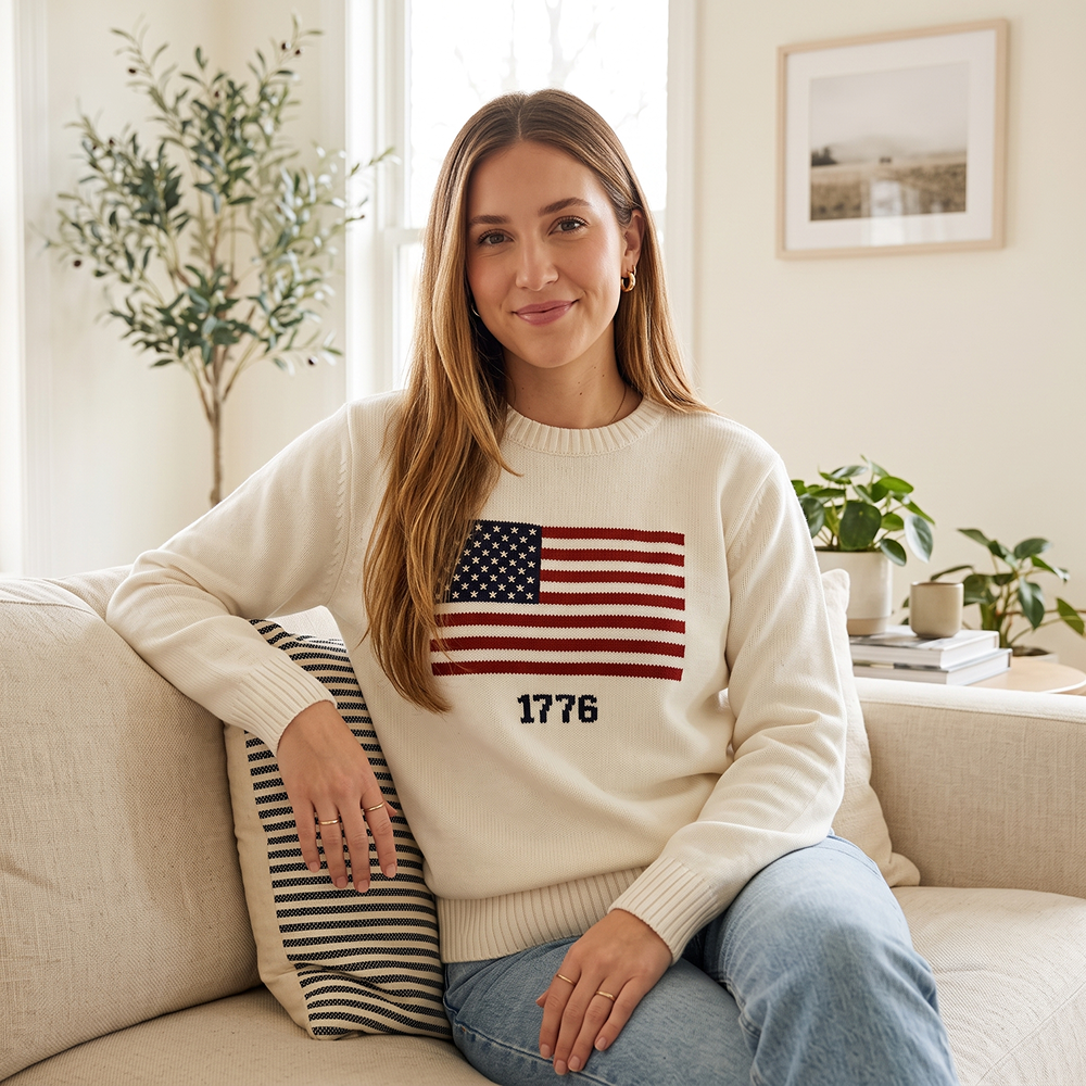 An outdoor lifestyle setting with a proud American adult wearing the white FOX News 1776 knit sweater in crisp autumn weather.