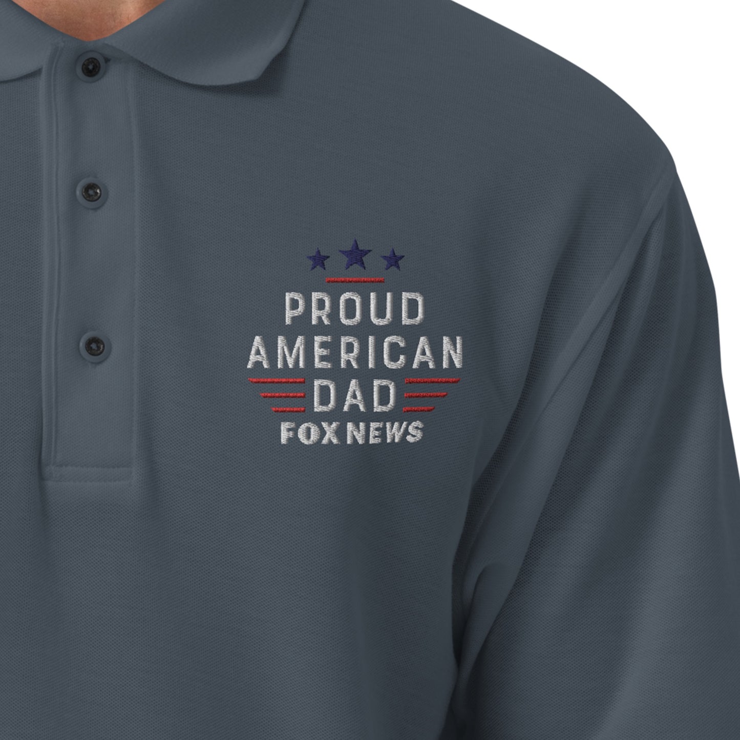 A crisp, detailed close-up shot highlighting the embroidered Proud American Dad chest logo on the FOX News polo shirt.