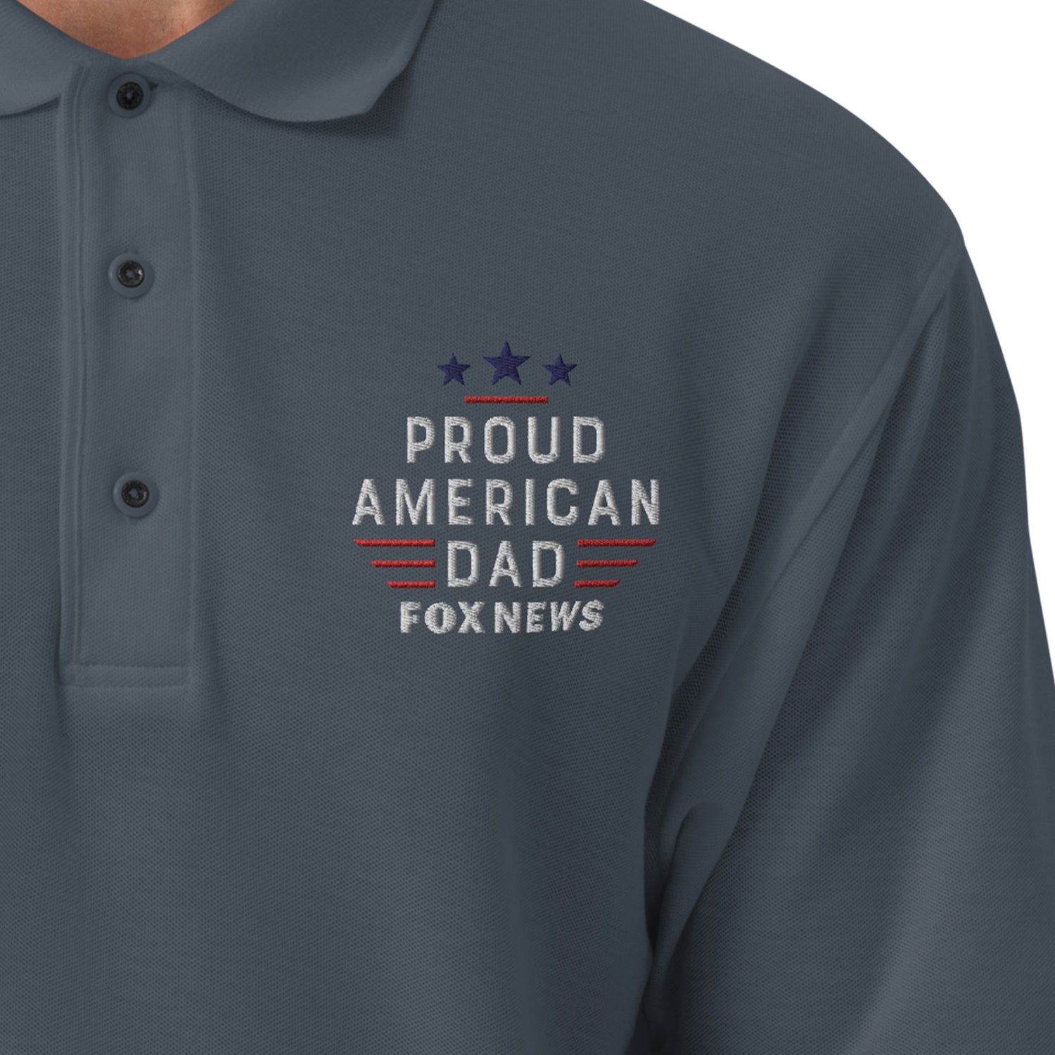 A crisp, detailed close-up shot highlighting the embroidered Proud American Dad chest logo on the FOX News polo shirt.