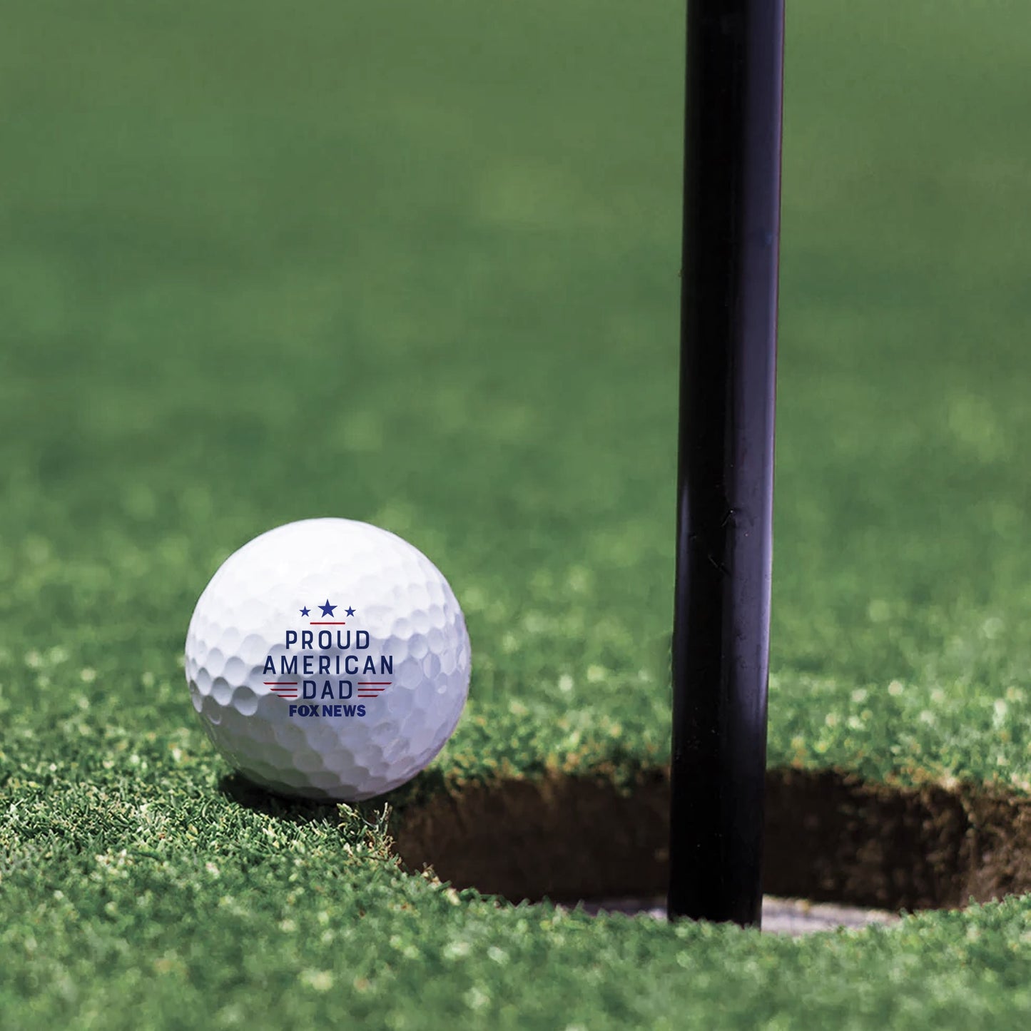 A Father's Day gift arrangement featuring the FOX News golf balls on a wooden table.