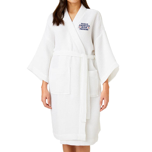A woman wearing the white FOX News Proud American Mom Embroidered Waffle Robe in a sunlit American home setting.
