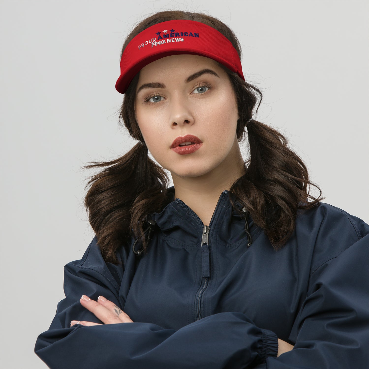 Close-up of the red FOX News Proud American visor showing the detailed embroidery and adjustable strap.