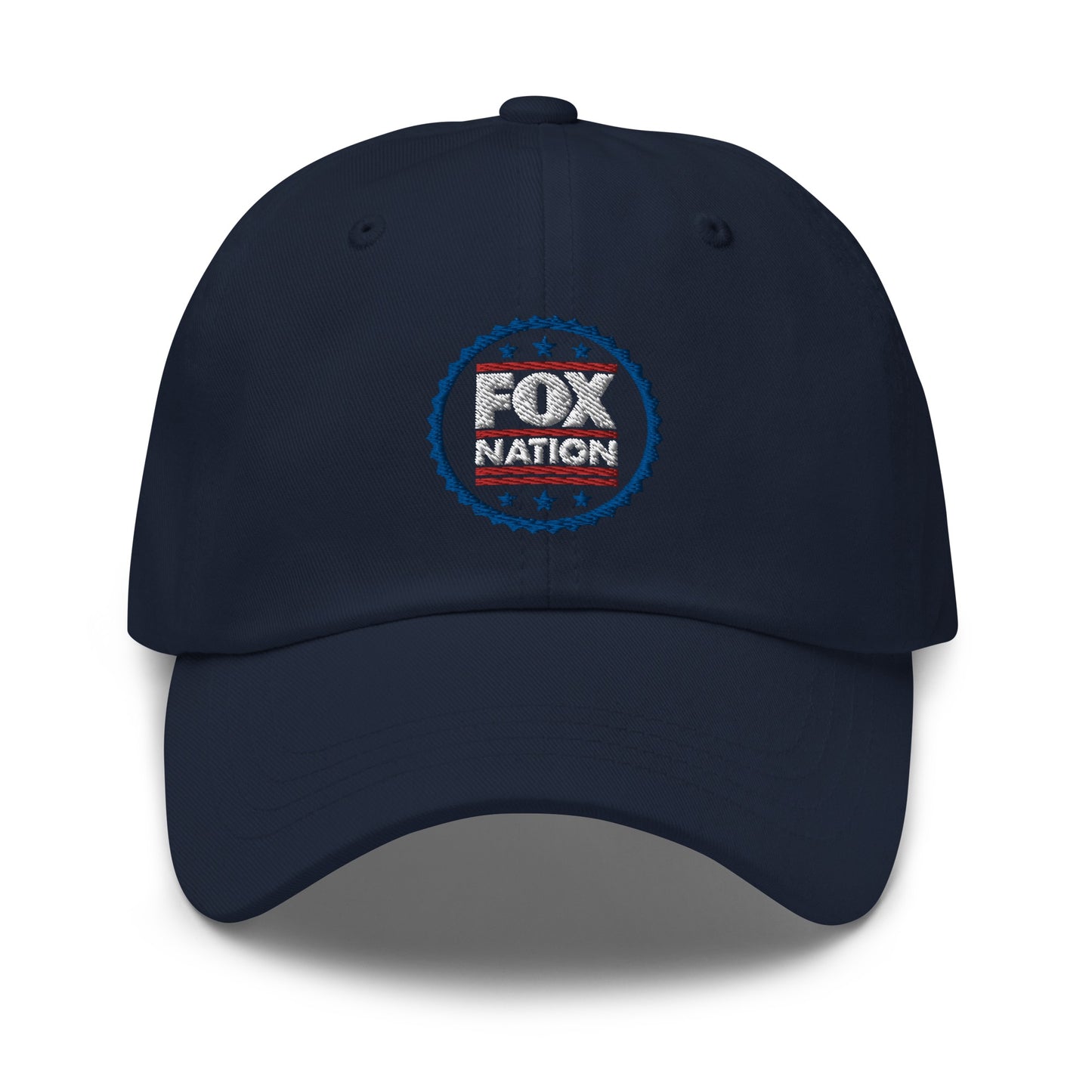 A navy blue FOX Nation Badge Embroidered Hat resting on a clean wooden table in a bright, modern American sunroom.
