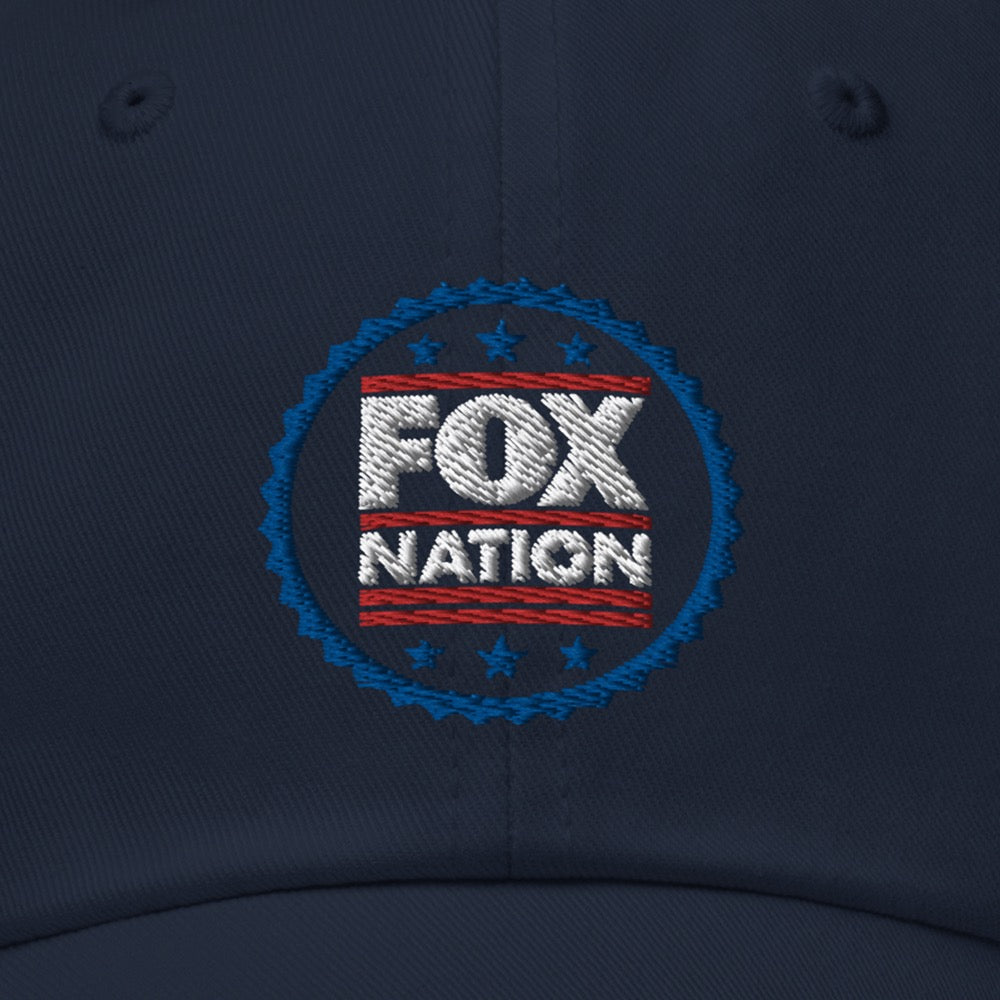 Close-up of the crisp, high-quality FOX Nation logo badge embroidered on the front of a navy blue baseball cap.