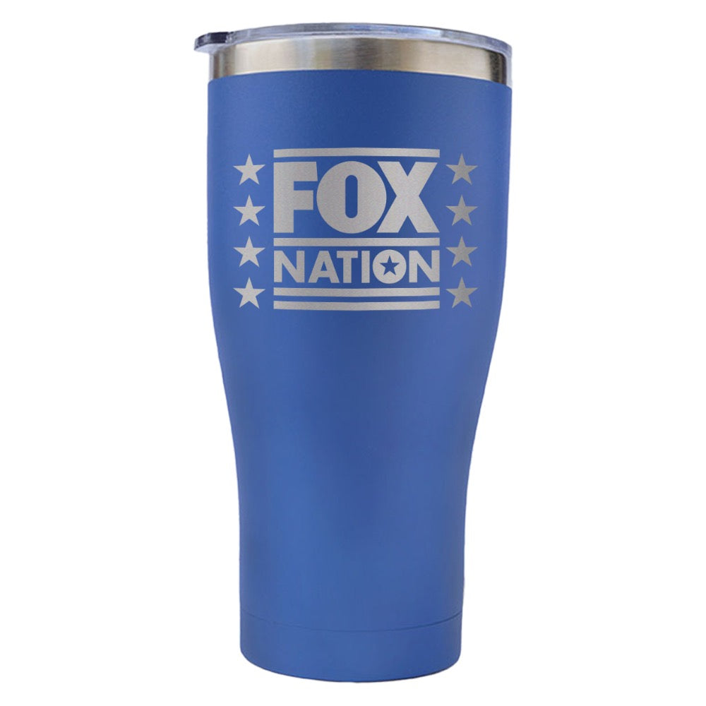 The FOX Nation Stars Tumbler resting next to a newspaper in a brightly lit American home.
