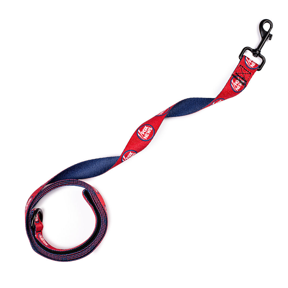 Close-up of the crisp FOX News logo on a high-quality pet lead held by a person in a backyard.