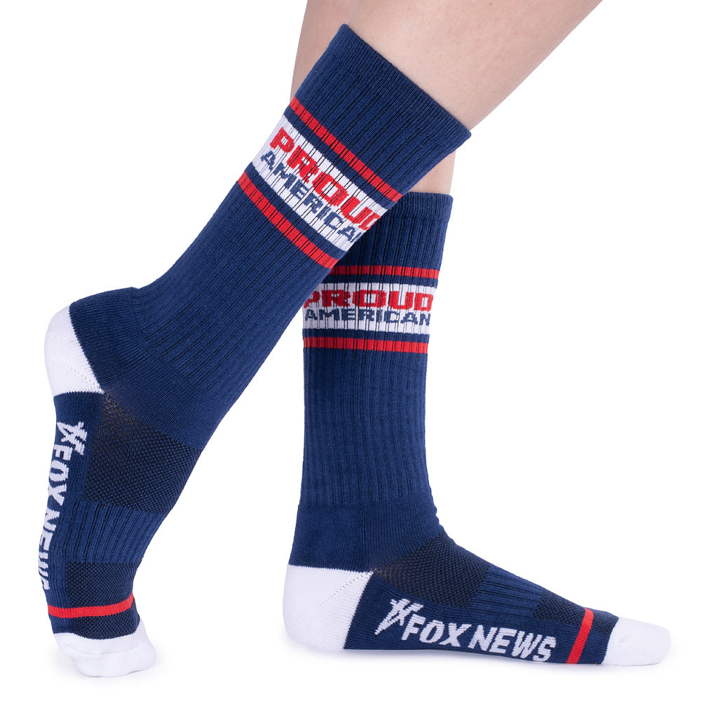 The white athletic socks featuring a bold *Proud American* graphic displayed against a bright backyard background.