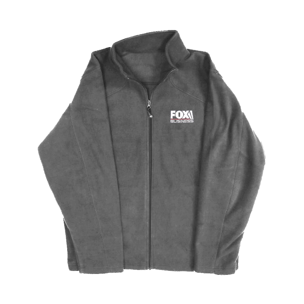 A woman wearing the official *FOX Business* Women's Charcoal Fleece Jacket in a clean American home setting, showcasing the crisp logo placement and professional fit.