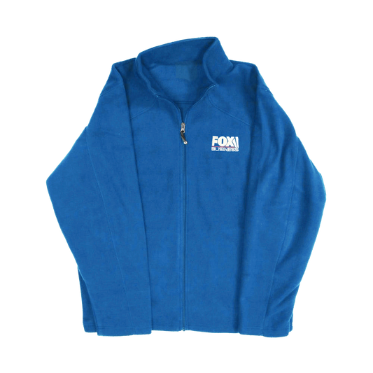 A professional women's royal blue fleece jacket featuring the FOX Business logo placement, shown in a clean American home setting.