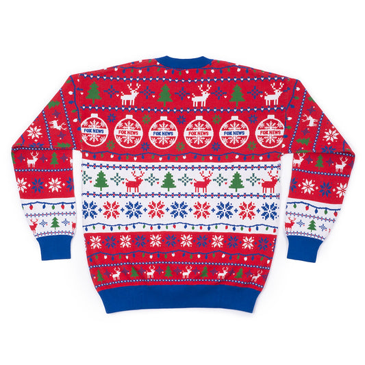 A patriotic viewer smiling proudly while wearing the FOX News Knit Holiday Sweater in a warm, suburban home setting.
