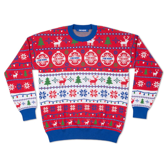 A cozy, modern American living room decorated for the holidays, featuring a neatly folded FOX News Knit Holiday Sweater on a wooden coffee table.