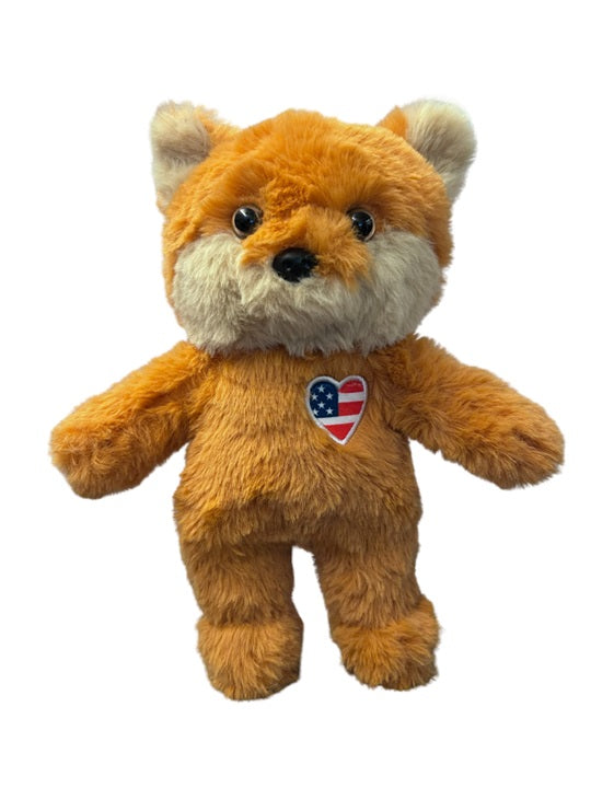A Caucasian child holding the For All America Fox Plush in a suburban home nursery.