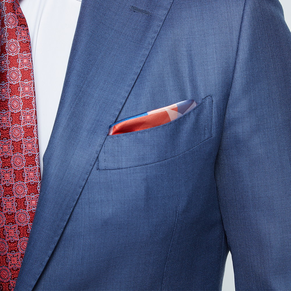 The FOX News American Flag Pocket Square neatly folded on a clean wooden surface, highlighting the bold red, white, and blue colors.