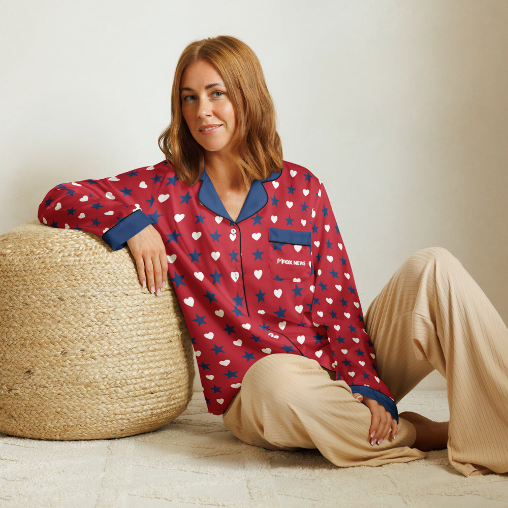 A lifestyle shot of a confident American woman relaxing indoors while wearing the FOX News Proud American pajama top.