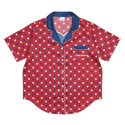 Close-up product shot of the FOX News Proud American pajama top laid flat, highlighting the crisp red, white, and blue hearts and stars graphic and FOX News logo.