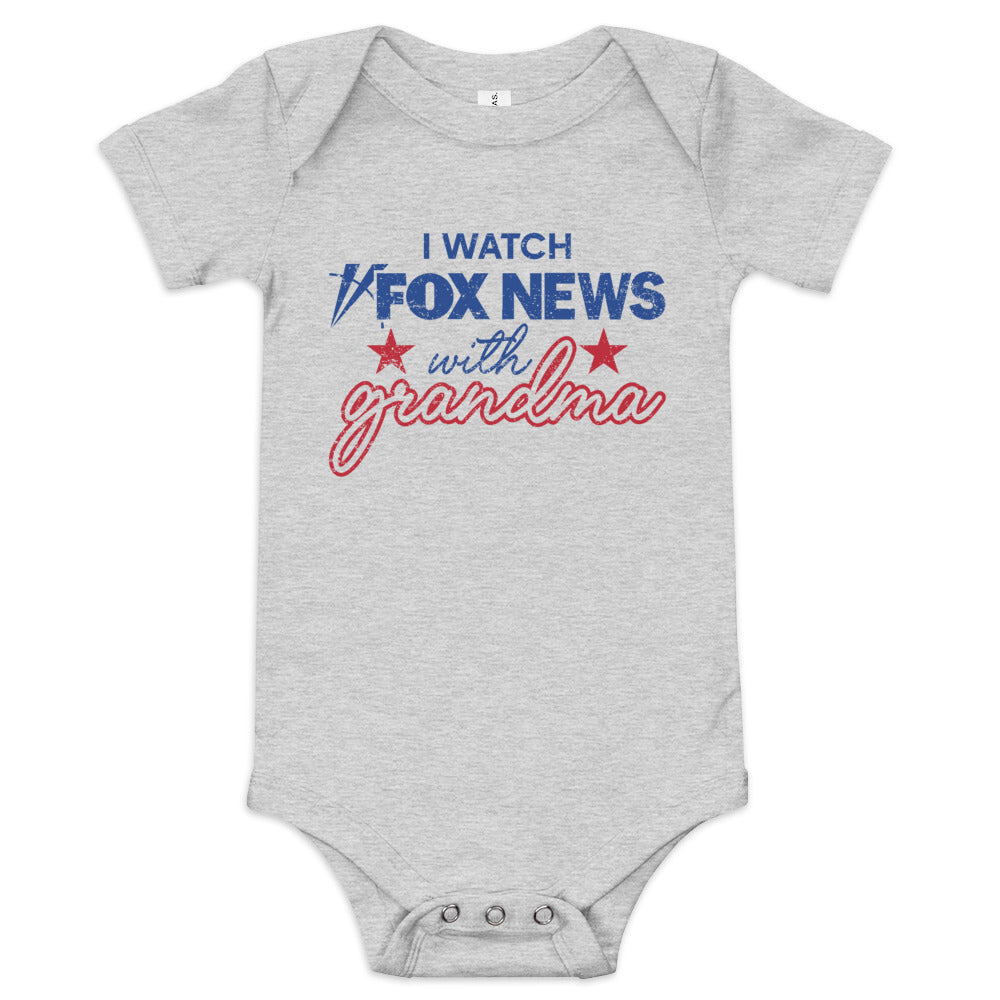 An infant wearing the white FOX News I Watch with Grandma bodysuit in a sunlit, clean American nursery.
