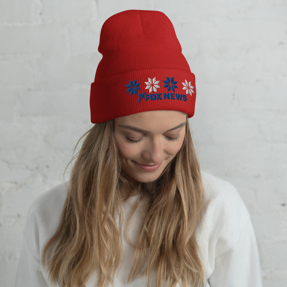 The *FOX News* Holiday Snow Embroidered Beanie in Heather Grey placed neatly on a wooden table in a brightly lit American sunroom.