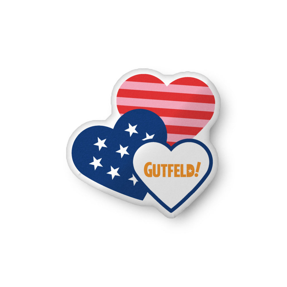 A crisp Gutfeld! Hearts Pillow resting on a clean, white sofa in a sunlit American suburban living room.