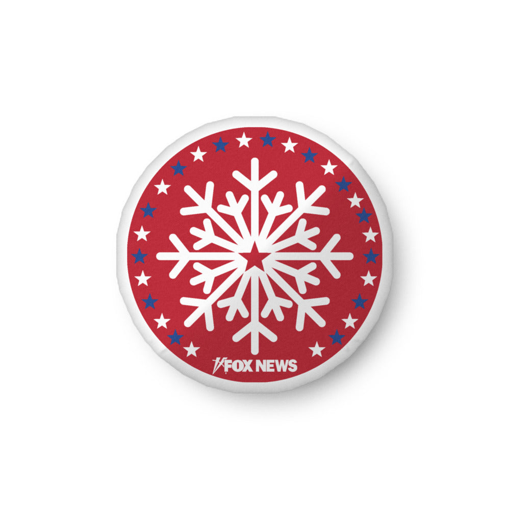 A FOX News Holiday Snowflakes Pillow featuring a white snowflake pattern and the FOX News logo in a clean American living room setting.