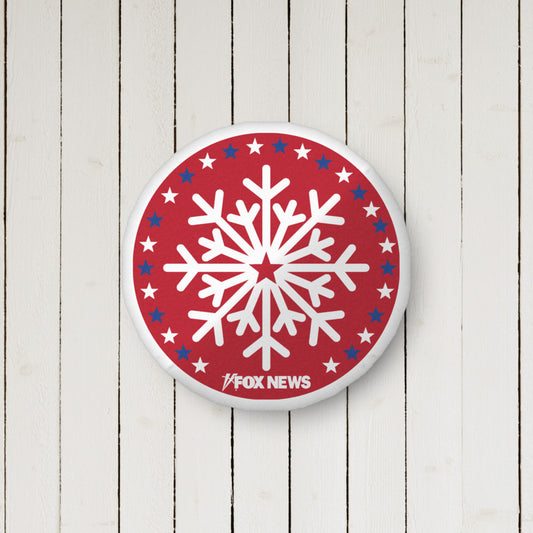 A FOX News Holiday Snowflakes Pillow featuring a white snowflake pattern and the FOX News logo in a clean American living room setting.-1