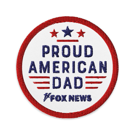 The circular FOX News Proud American Dad patch displayed proudly on a classic navy jacket in a bright American living room setting.