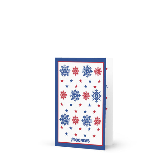 A FOX News Holiday Snowflakes Greeting Card resting on a clean wooden table in a sunlit American home.-2