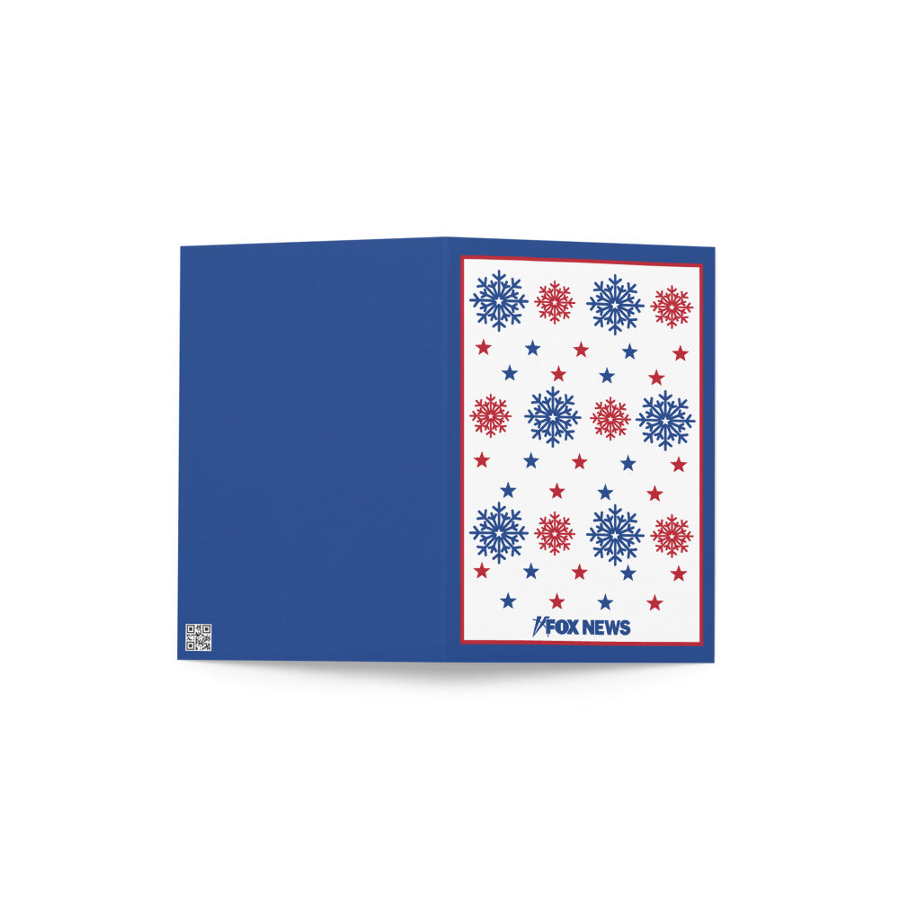 A FOX News Holiday Snowflakes Greeting Card resting on a clean wooden table in a sunlit American home.