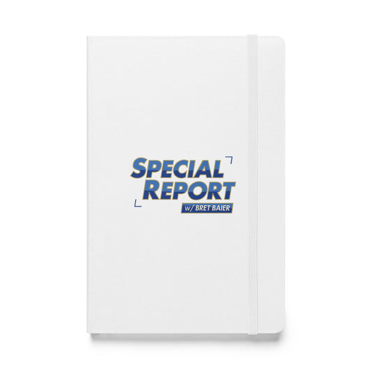 A white Special Report with Bret Baier journal resting next to a cup of coffee in a bright, professional suburban living room environment.