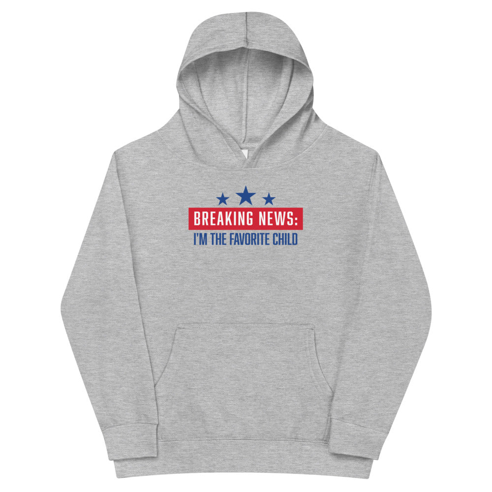 A child wearing the FOX News Breaking News Kids Hoodie in Athletic Heather, featuring the bold Breaking News logo, in a bright suburban home setting.