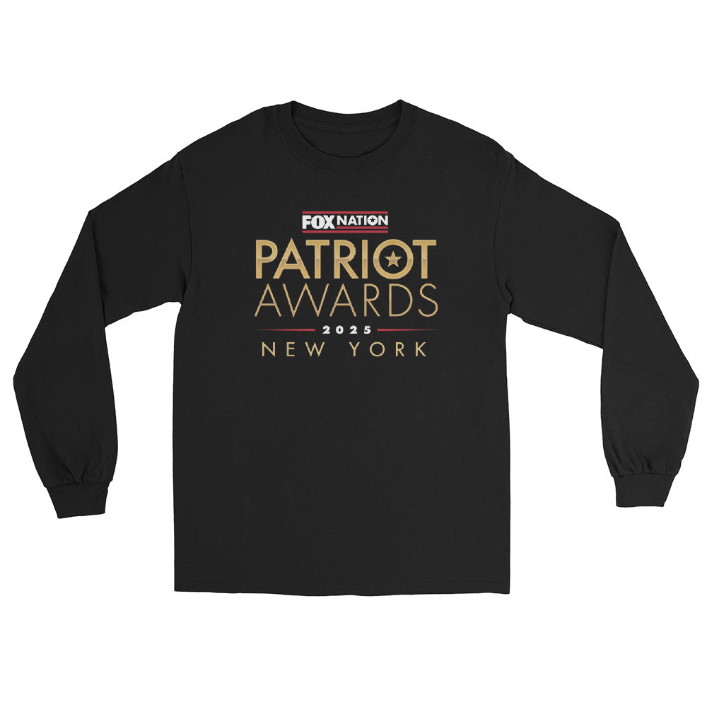 A patriot wearing the *FOX Nation* Patriot Awards 2025 Long Sleeve T-Shirt in a comfortable American home setting.