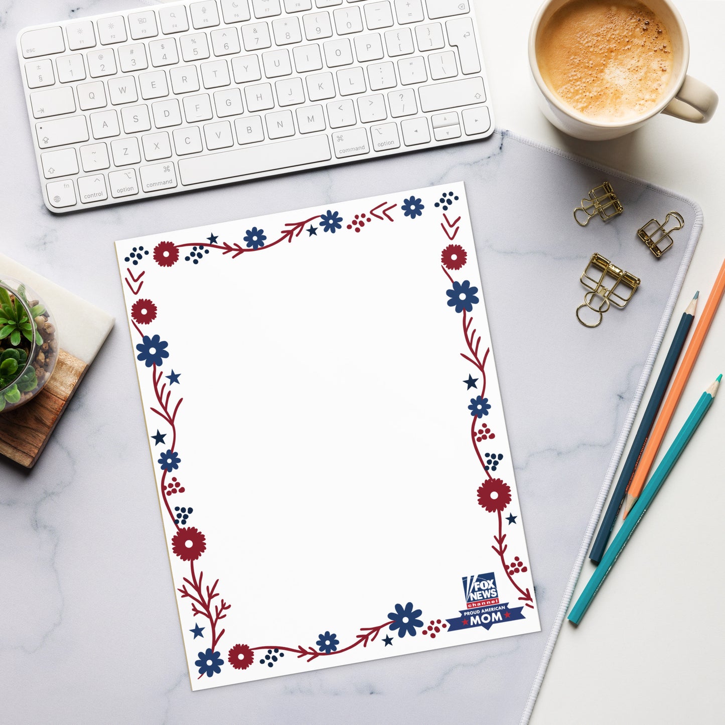 A Proud American Mom notepad sitting on a clean, modern American kitchen counter next to a coffee mug.