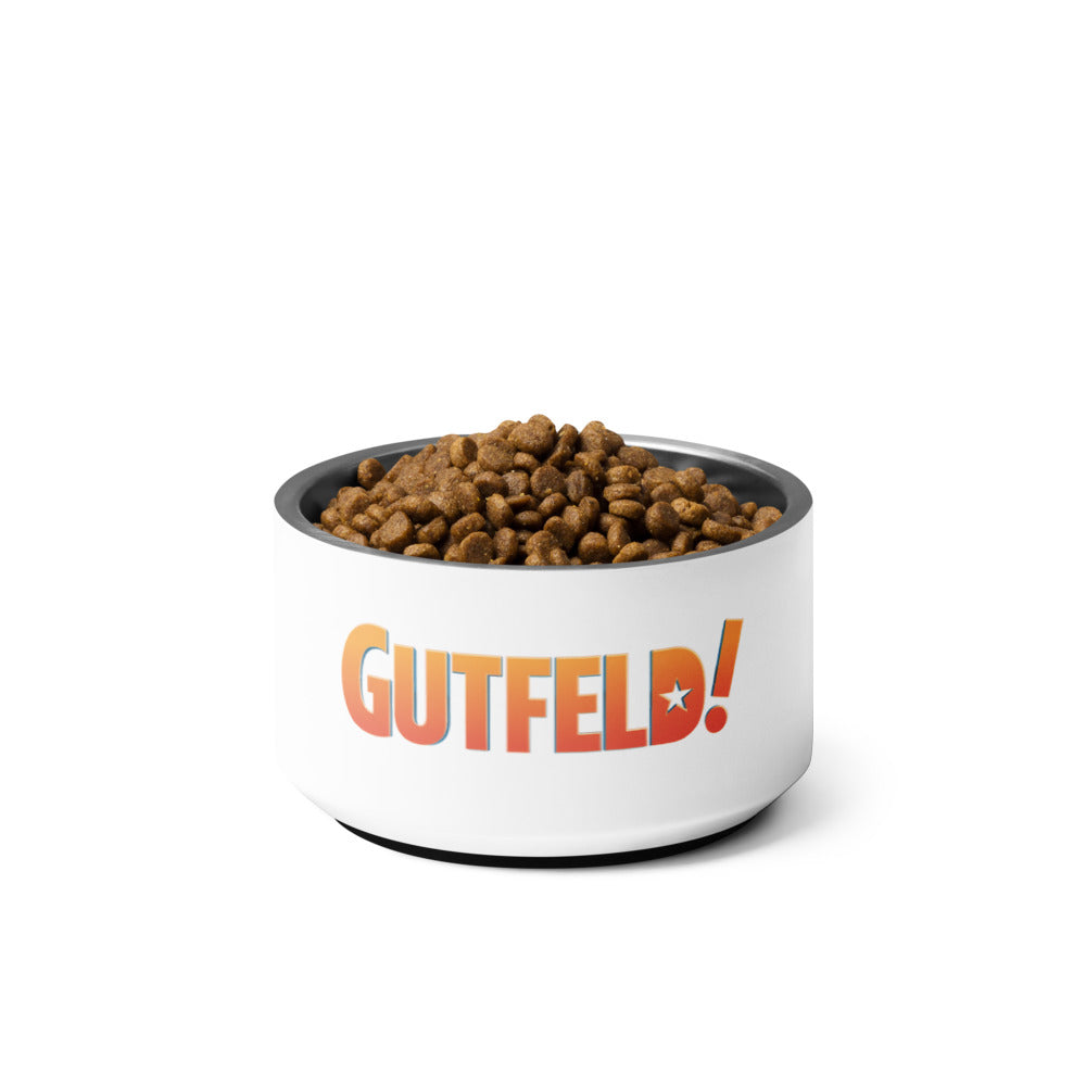 A crisp, clean pet bowl featuring the bold *Gutfeld!* logo, displayed in a modern American living room setting.