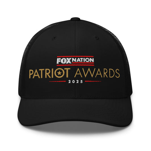 Front view of the black FOX Nation Patriot Awards 2025 Trucker Hat showing the crisp logo in a clean, modern American home setting.
