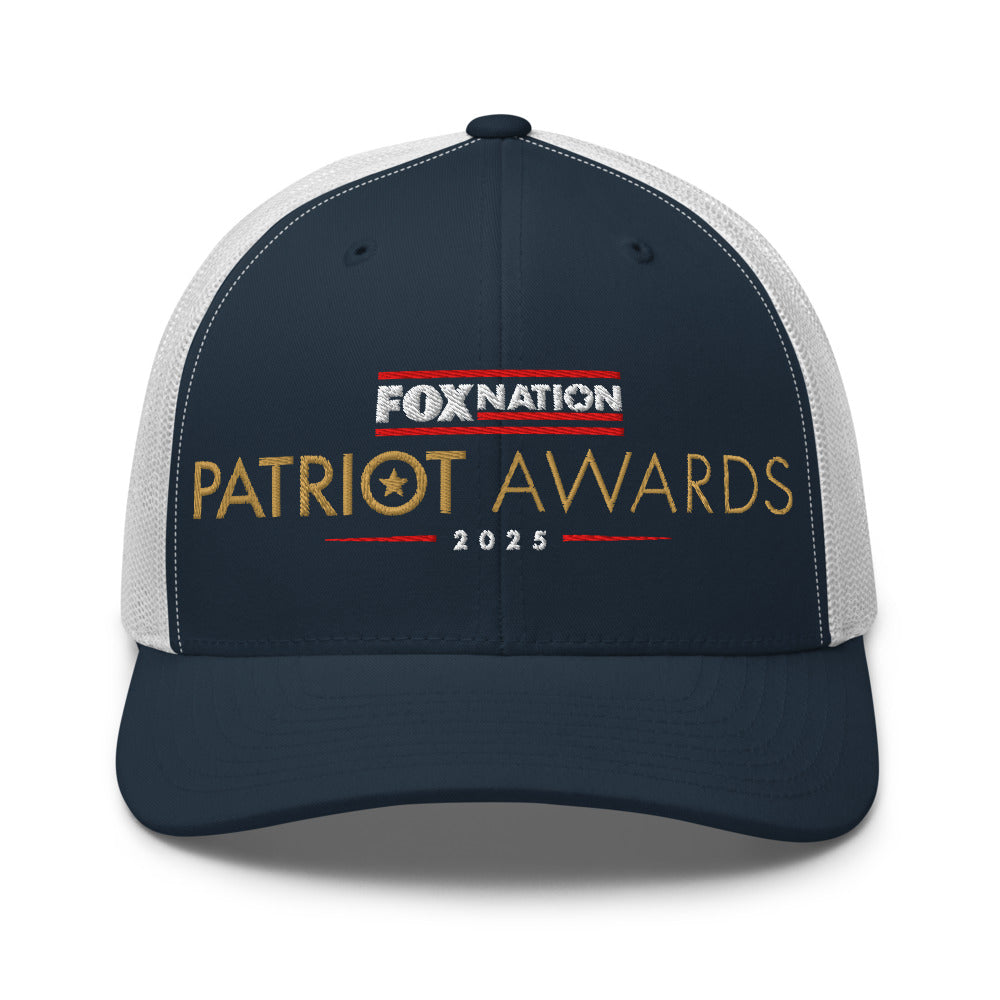 Top-down view of the FOX Nation Patriot Awards 2025 Trucker Hat on a clean wooden surface.